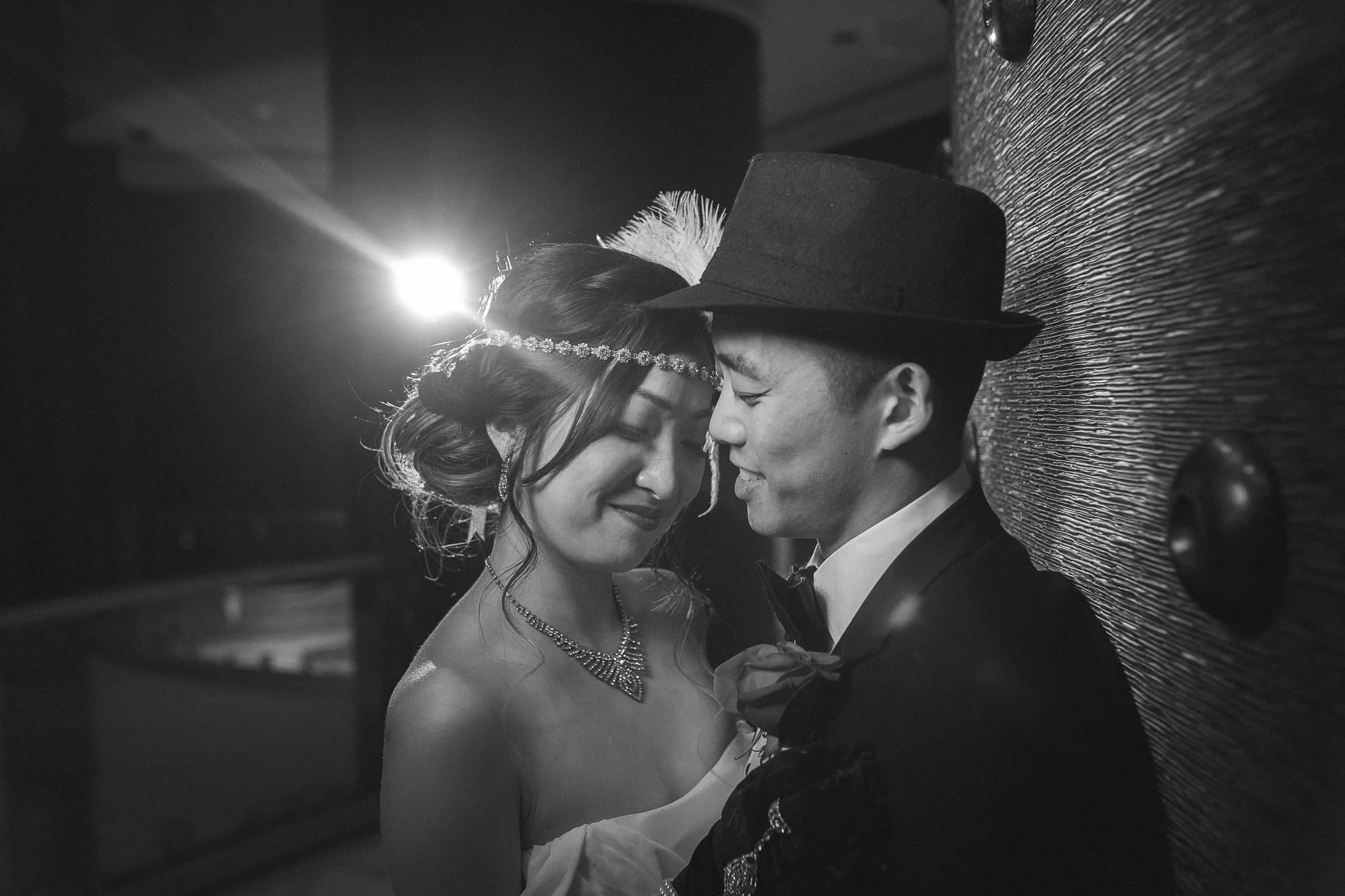 Newlyweds share a quiet moment in a dramatic black-and-white portrait