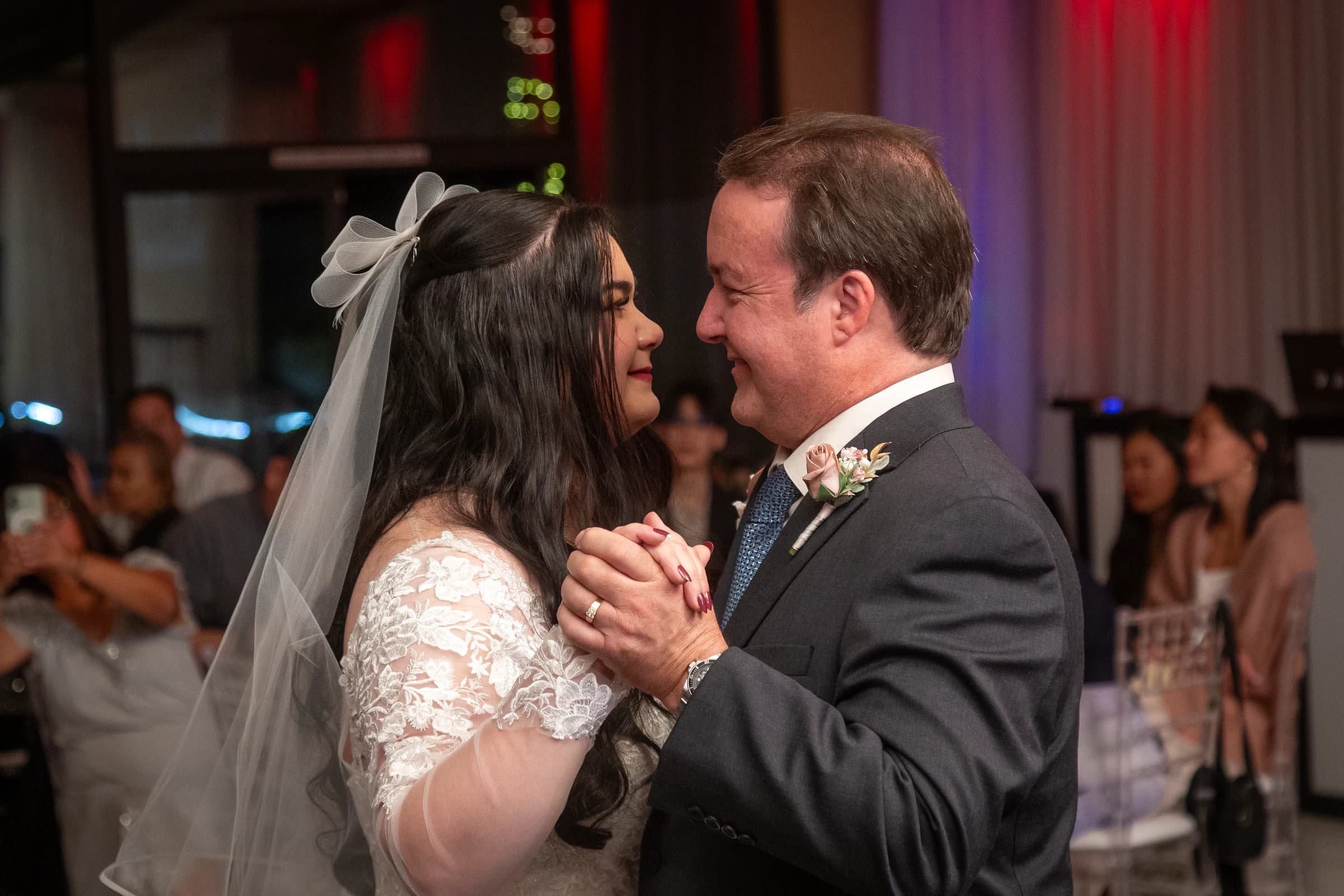 A bride shares a warm reception dance with a parent