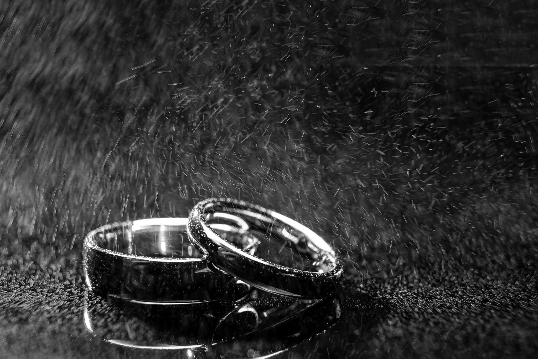 Wedding rings reflected in water droplets in black and white