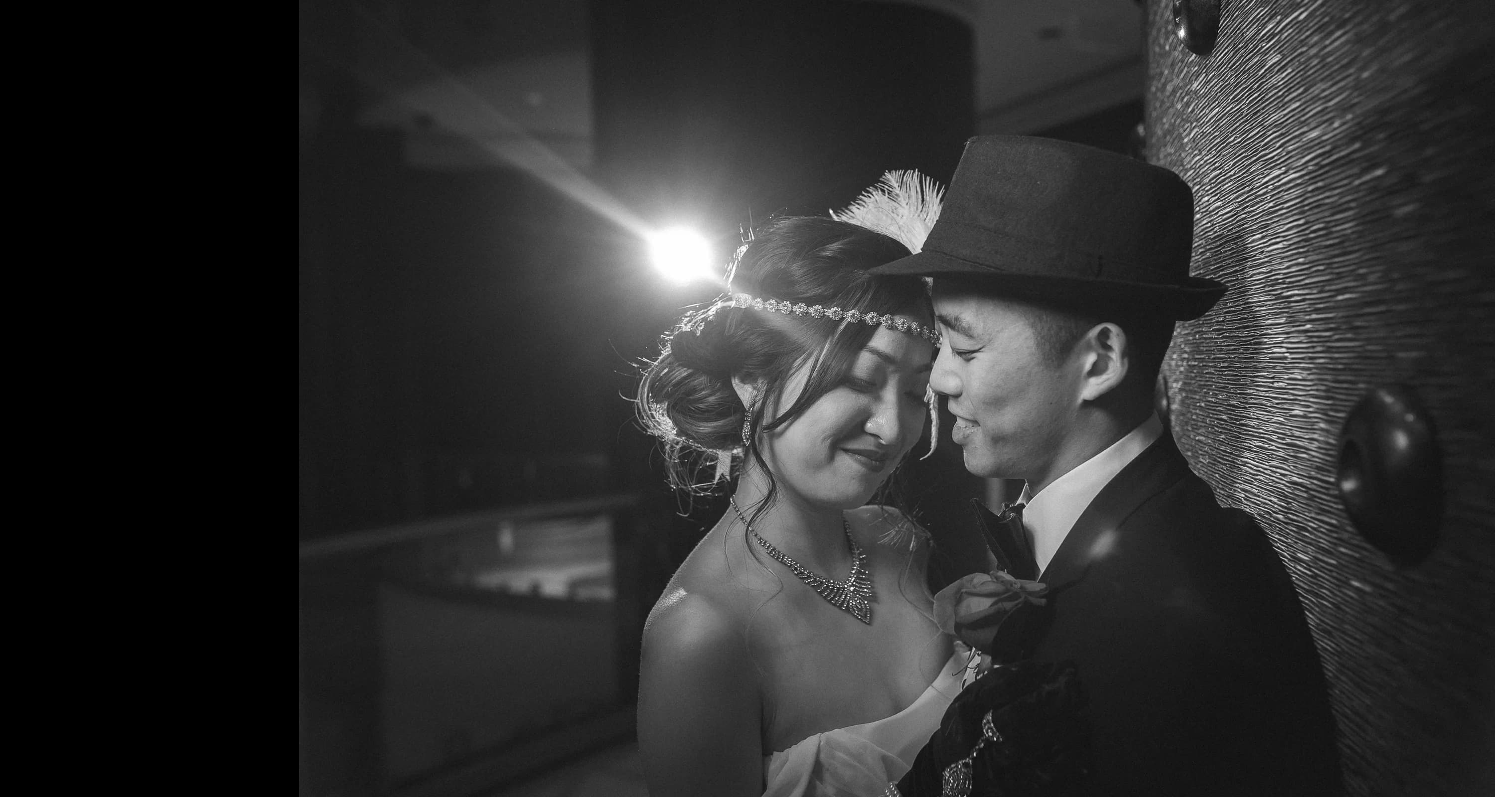 Newlyweds share a quiet moment in a dramatic black-and-white portrait
